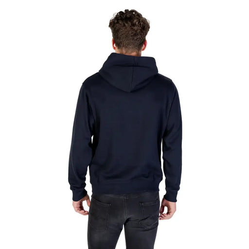 Men’s dark blue hooded sweatshirt with front pocket paired with black jeans
