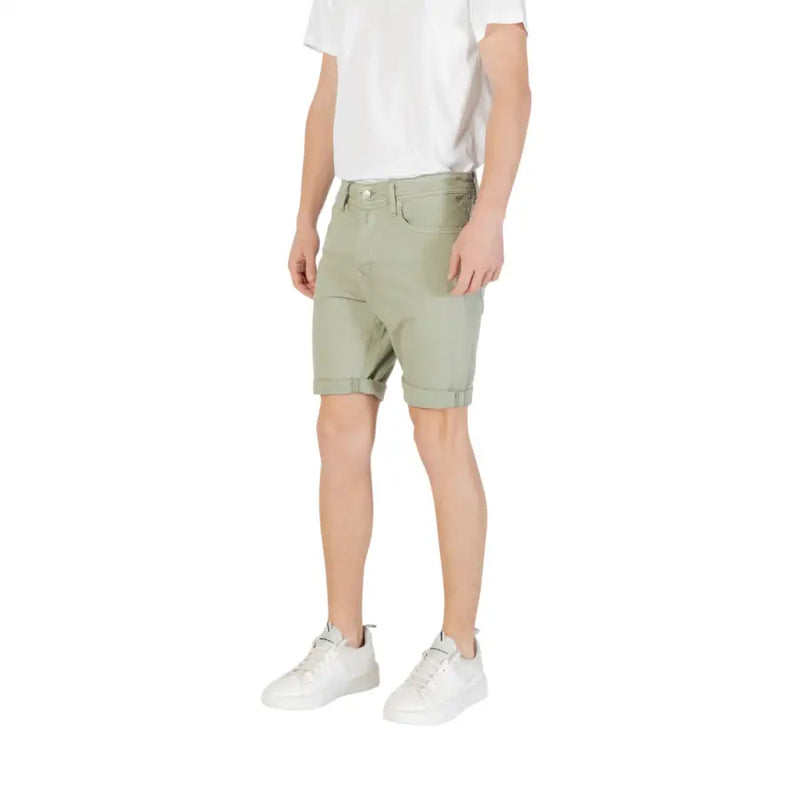 Olive green chino shorts with rolled hem and white sneakers