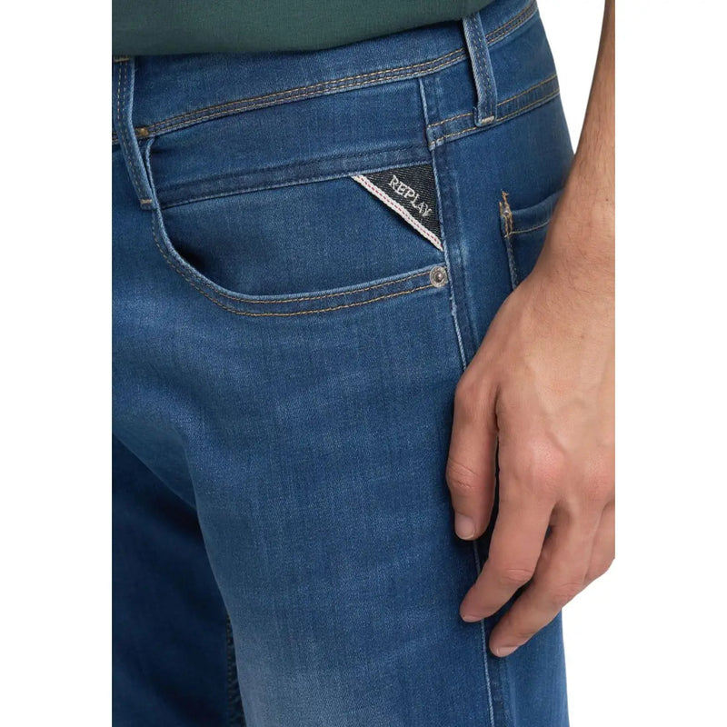 Back side of replay men jeans blue slim fit denim with subtle fade and triangular brand tag on pocket spring summer