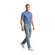 Ein Mann in hellblauen Replay Herrenjeans (Regular Slim) aus Baumwollstretch und einem hellblauen Poloshirt, stehend in Frontansicht.