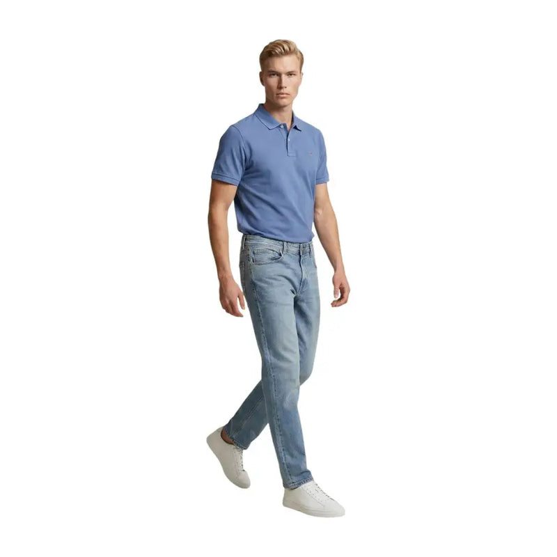Ein Mann in hellblauen Replay Herrenjeans (Regular Slim) aus Baumwollstretch und einem hellblauen Poloshirt, stehend in Frontansicht.