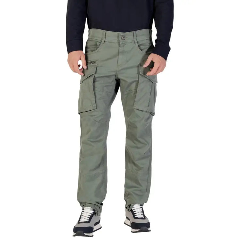 Men’s olive green cargo pants with black long-sleeve shirt and grey black sneakers