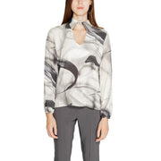 A woman wears a rinascimento grey print long sleeve viscose blouse with black and white brushstroke pattern and keyhole neckline
