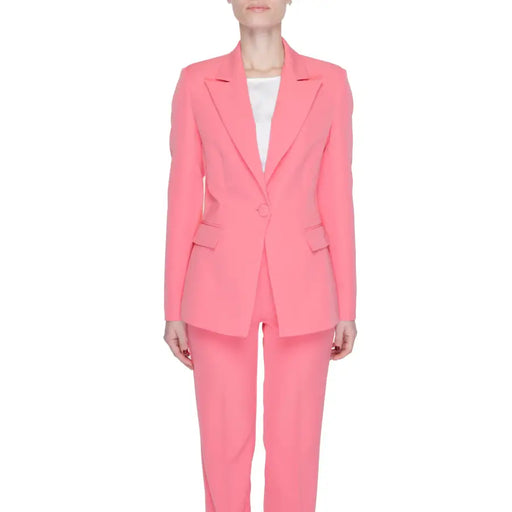 A vibrant coral pink tailored women’s blazer with lapel collar front pockets and matching trousers by Silence Women