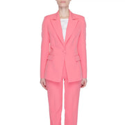 A vibrant coral pink tailored women’s blazer with lapel collar front pockets and matching trousers by Silence Women