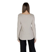 Women wearing beige long-sleeve boat neck knit sweater with black trousers for a stylish look