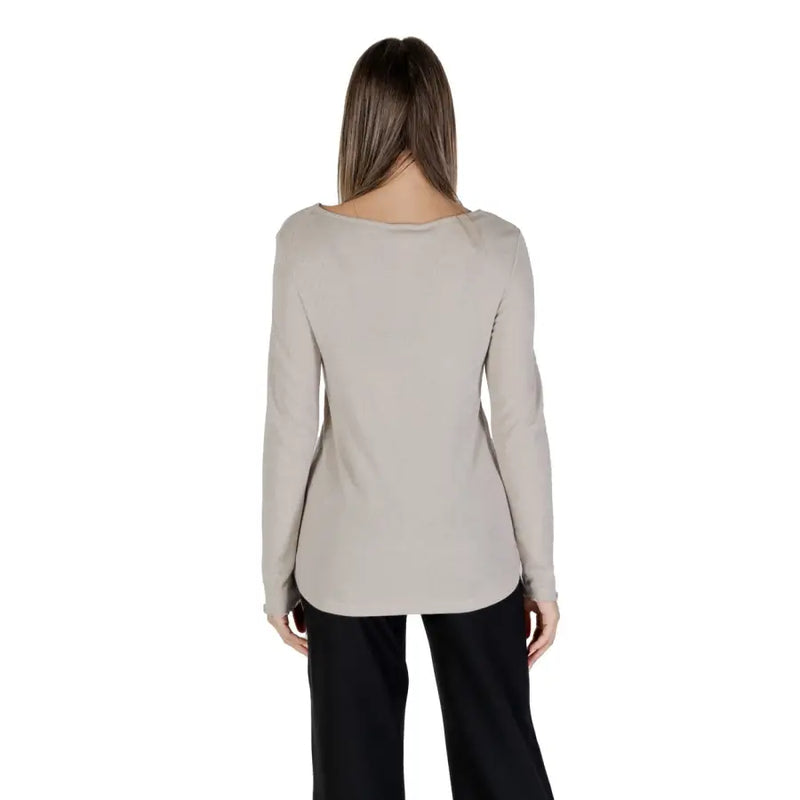 Women wearing beige long-sleeve boat neck knit sweater with black trousers for a stylish look