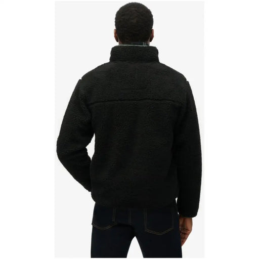 Men’s black fleece jacket and dark wash jeans displayed in Superdry Men Fall Winter blazer