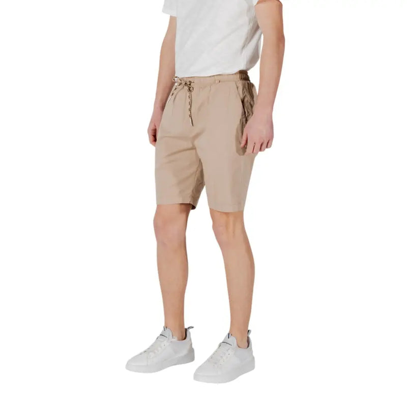 Tan drawstring shorts made of beige cotton with a drawstring waist and subtle side pockets for casual wear