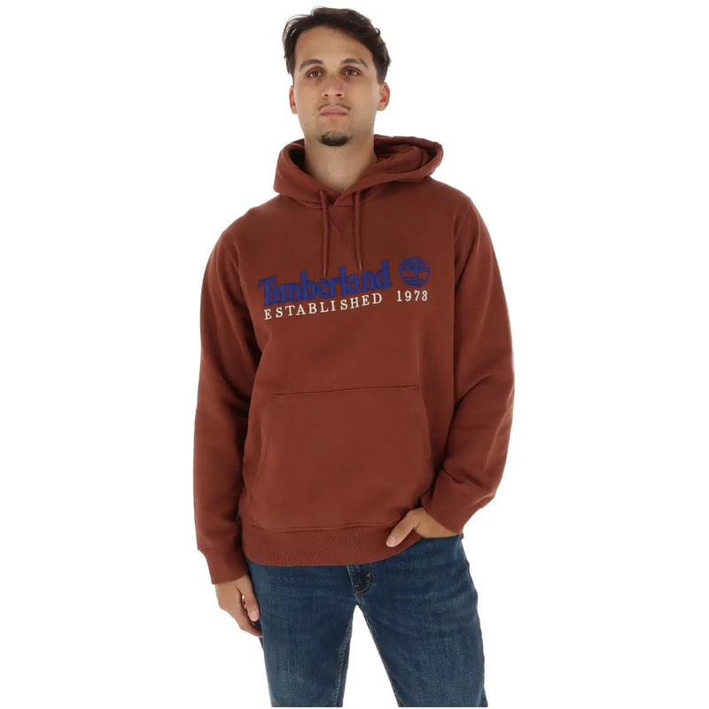 Brun Timberland Sweat à capuche avec logo bleu et blanc sur la poitrine, associé à un sweat-shirt en coton gris avec poches en molleton.