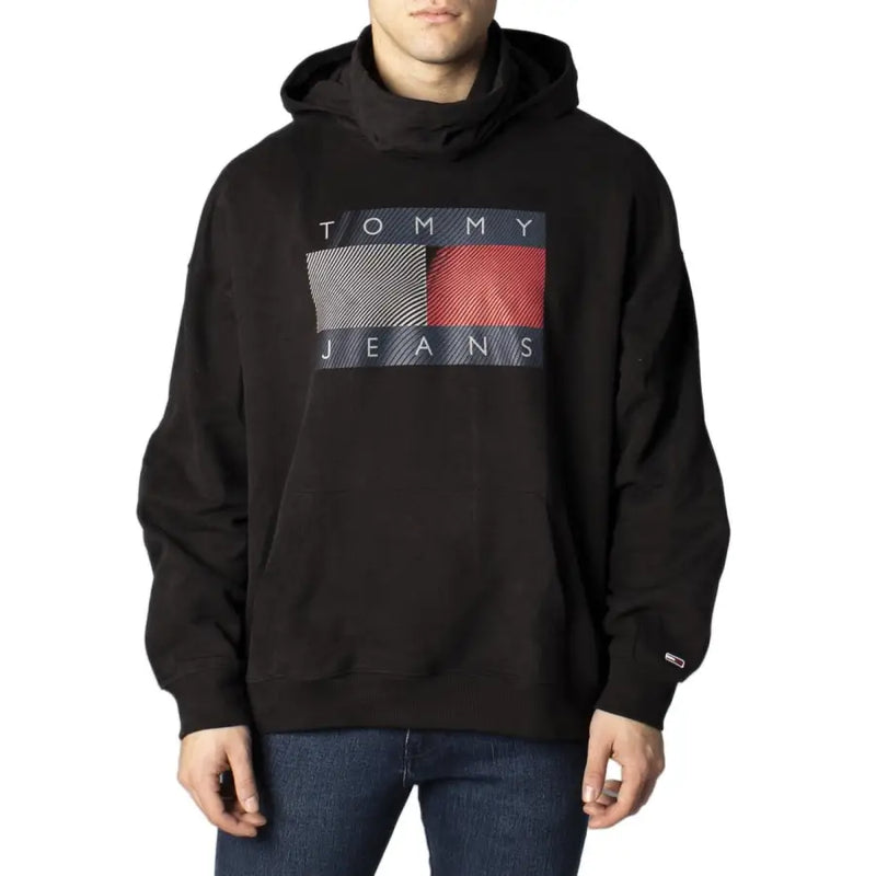 Tommy Hilfiger black hooded sweatshirt for men with bold graphic logo and gray red diagonal stripes on dark blue background