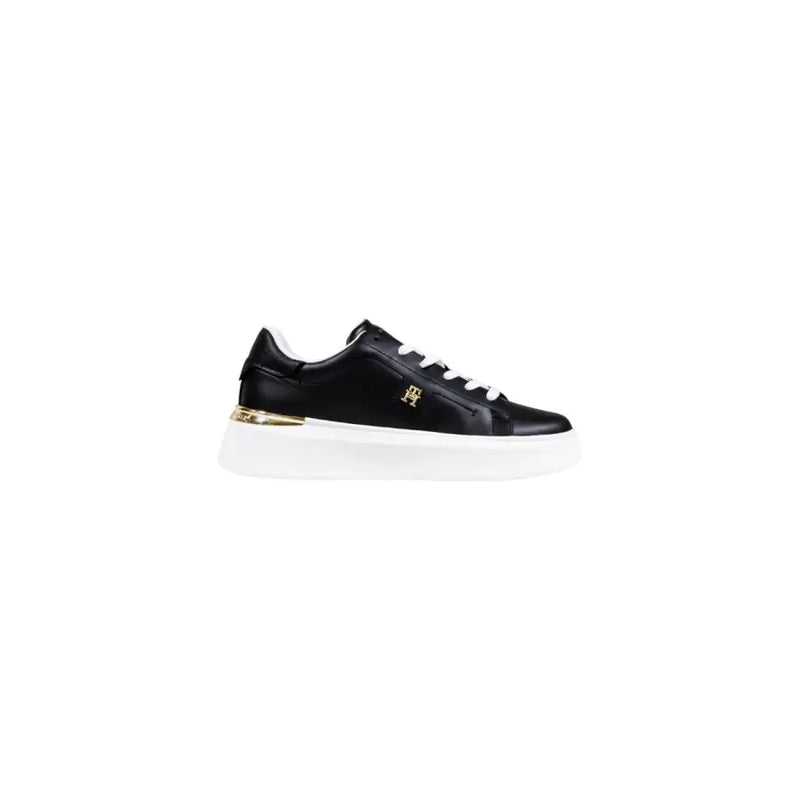 Black leather sneakers with gold accents and white laces.
