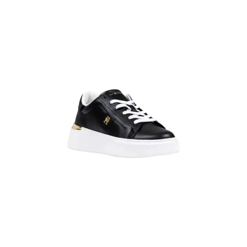 Black leather sneaker with white sole and gold accents, featuring a lace-up design.