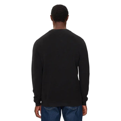 Black crew neck long-sleeve t-shirt with ribbed cuffs and hem, made of cotton.