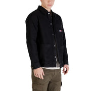 Schwarze Tommy Hilfiger Arbeitsjacke mit Knopfleiste, Brusttasche und dem ikonischen Flaggenlogo, das auch auf dem Tommy Hilfiger Jeanshemd für Herren zu sehen ist.