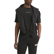 Black tommy hilfiger jeans hoodie draped over matching black t shirt and pants with subtle white chest branding