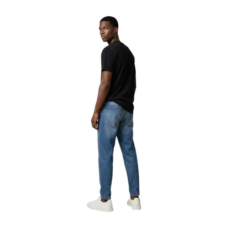 Un jean en denim bleu délavé moyen, à la coupe droite classique, de Tommy Hilfiger collection homme