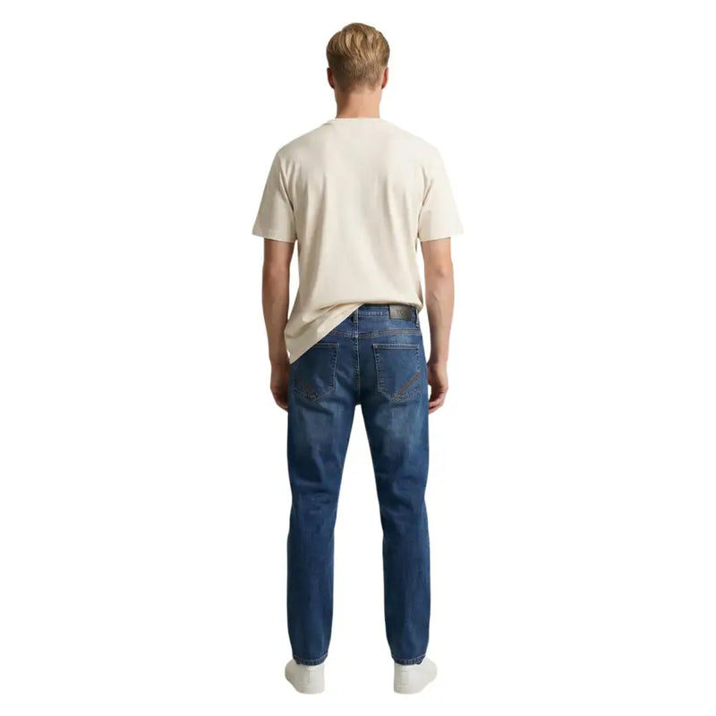 Blue denim jeans for men by tommy hilfiger with classic five-pocket design and slightly faded wash in organic cotton