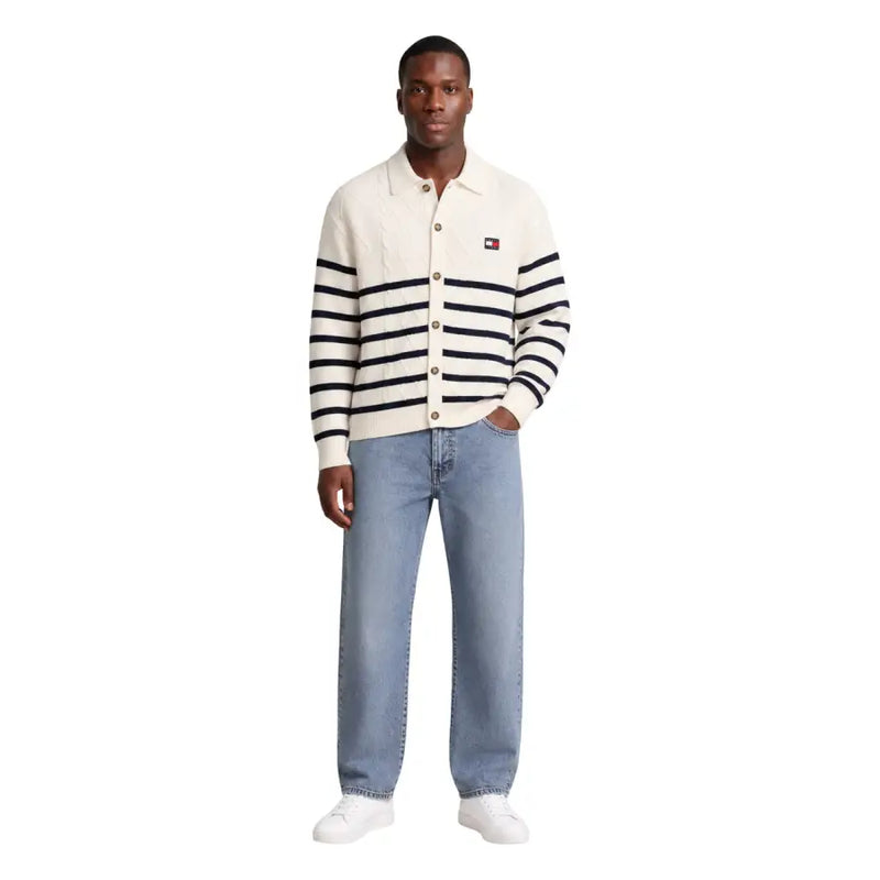 Cream-colored knit cardigan with black stripes and tommy hilfiger logo patch complementing men’s white organic cotton sweatshirt