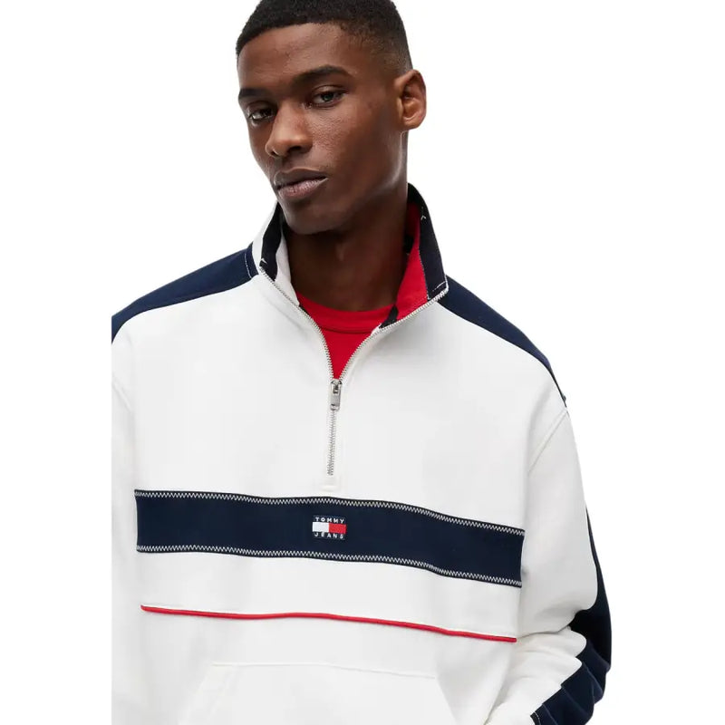 Tommy Hilfiger Jeans Sweat-shirt à demi-zip en coton biologique blanc pour homme, orné de détails bleu marine et rouges et d'un motif rayé sur la poitrine.