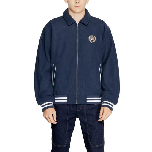 Tommy Hilfiger Jeans mens navy blue bomber jacket with white zipper, sleeve stripes, and embroidered chest crest