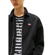 Black zip-up jacket with red, white, and blue flag logo over black and white striped shirt