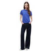 A woman wears a vibrant royal blue Tommy Hilfiger organic cotton t shirt paired with dark indigo wide-leg jeans