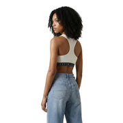 Cream-colored tommy jeans sports bra with black elastic band and logo, part of tommy hilfiger jeans women sleeveless round neck white top