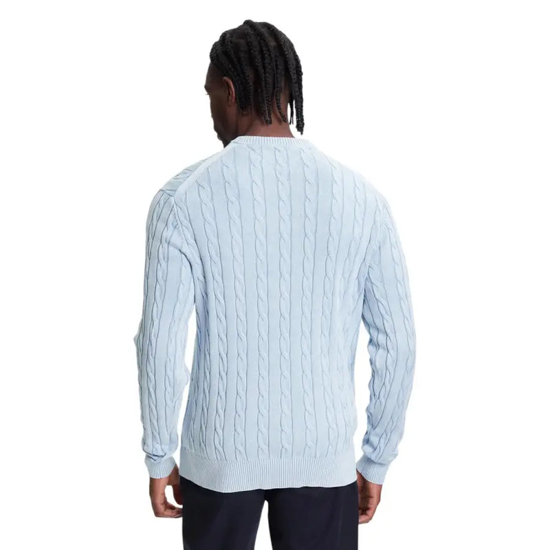 Light blue cable knit sweater with navy pants and dreadlocks.