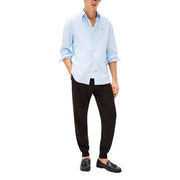 Light blue and white vertically striped cotton button-down shirt with rolled-up sleeves paired with tommy hilfiger men black cotton trousers