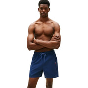 Tommy Hilfiger Short de bain homme bleu en polyester texturé marine, cordon de serrage bleu clair et logo sur le côté.