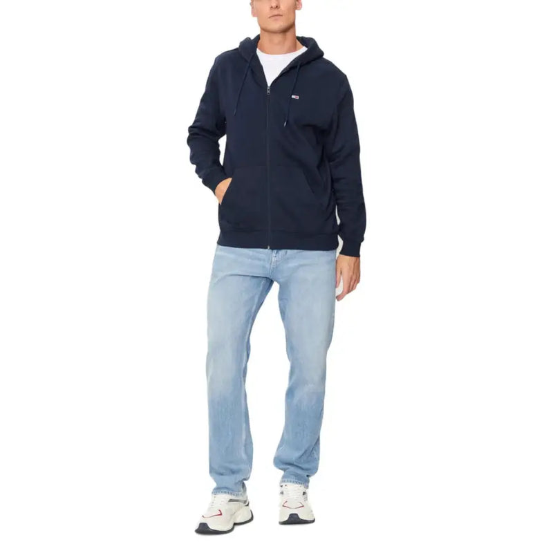Men’s navy blue zip-up hoodie paired with light wash jeans and white sneakers