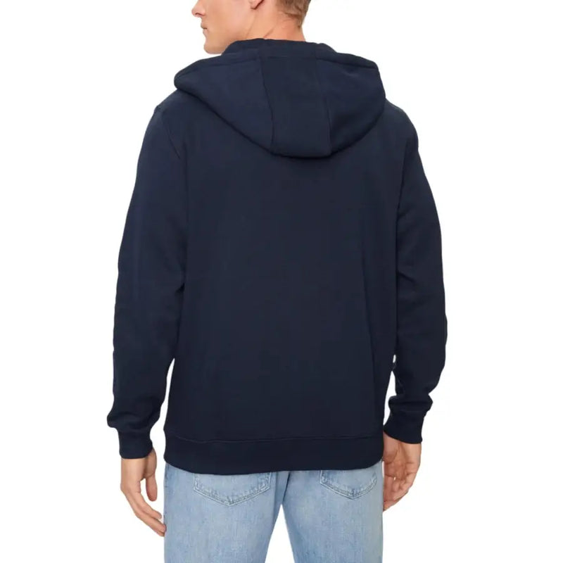 Men’s navy blue zip hooded sweatshirt paired with light blue jeans from Tommy Hilfiger
