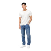A man wearing Tommy Hilfiger slim fit blue organic cotton jeans with a plain white short-sleeved t-shirt