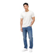 A man wearing Tommy Hilfiger slim fit blue organic cotton jeans with a plain white short-sleeved t-shirt