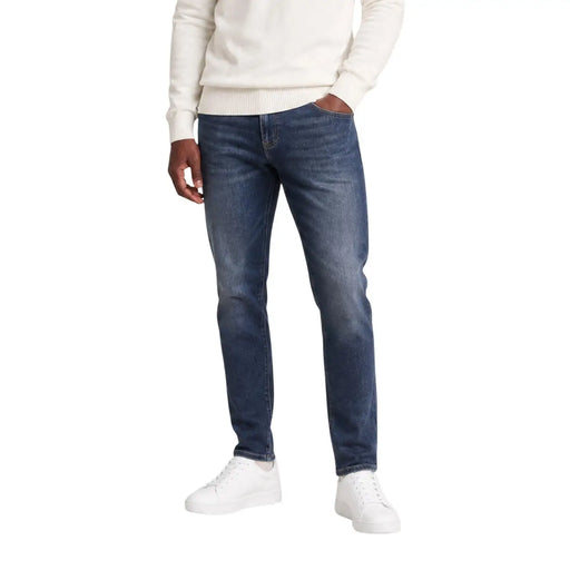 Tommy hilfiger men scanton slim blue jeans cotton with dark wash and subtle fading worn by a model in casual attire