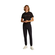 Tommy hilfiger men black slim cotton fleece trousers paired with a black t-shirt with white and pink stripes