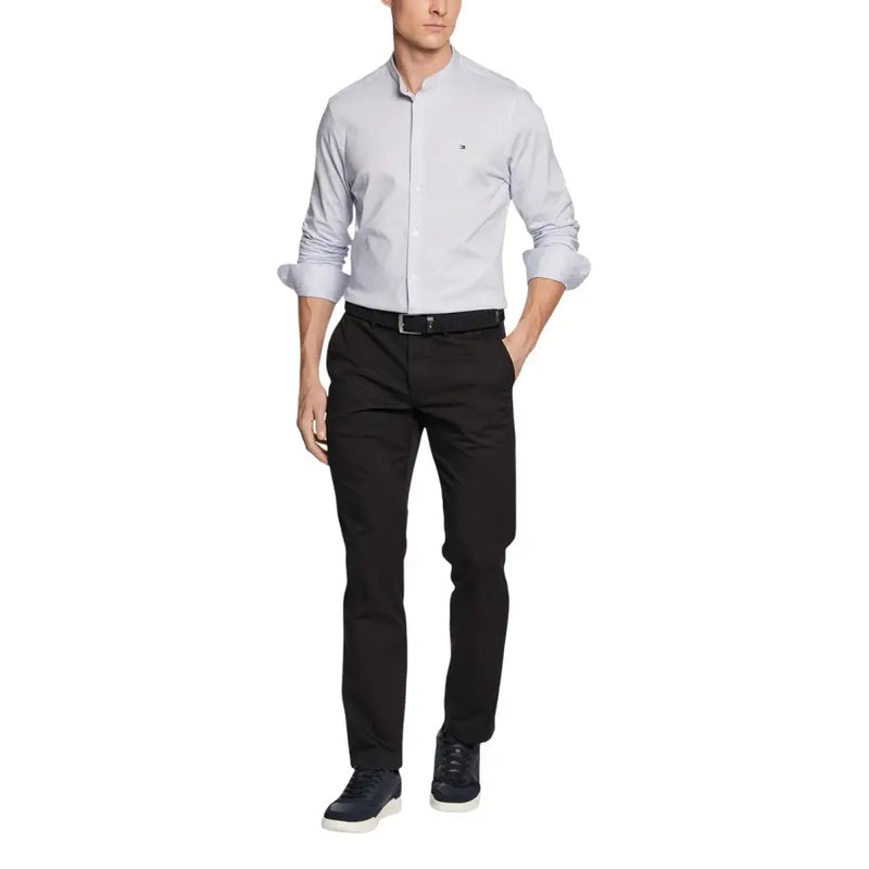 Chemise Tommy Hilfiger homme gris clair à manches retroussées et logo discret sur la poitrine, portée avec un pantalon.