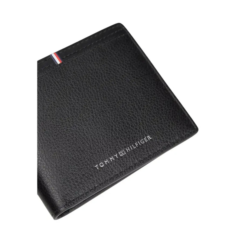 Tommy Hilfiger men wallet black textured leather with silver logo and red white blue striped tab visible on front side