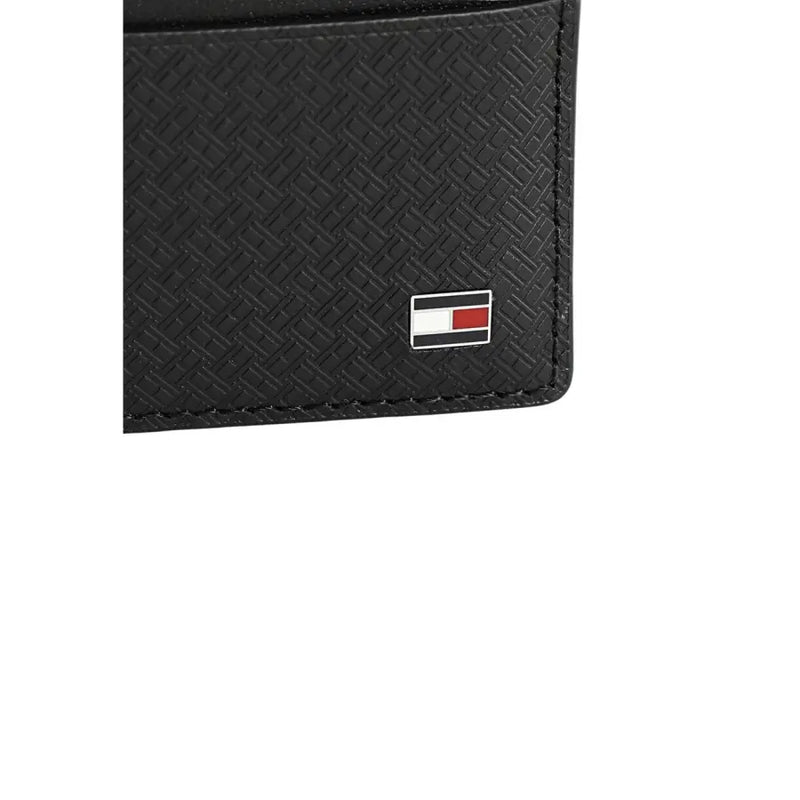 Tommy Hilfiger Herren-Geldbörse aus schwarzem, strukturiertem Leder mit dezentem Webmuster und ikonischem Flaggenlogo.