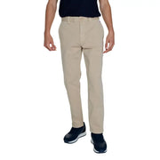 Men’s beige chino pants paired with a dark blue top and athletic shoes for fall winter style