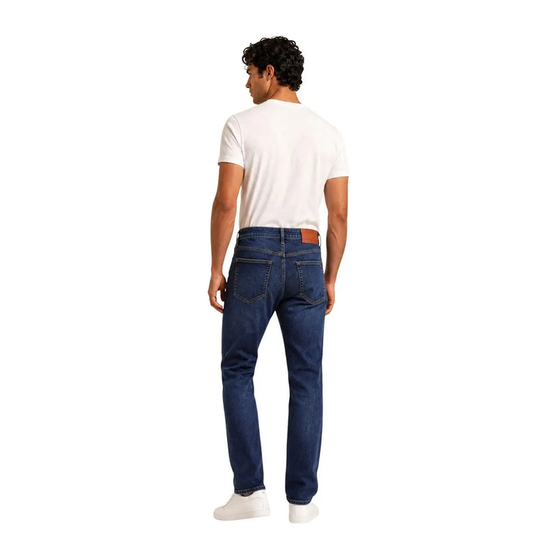 Tommy Hilfiger slim fit jeans for men in dark blue denim with five pockets and brown leather patch back view