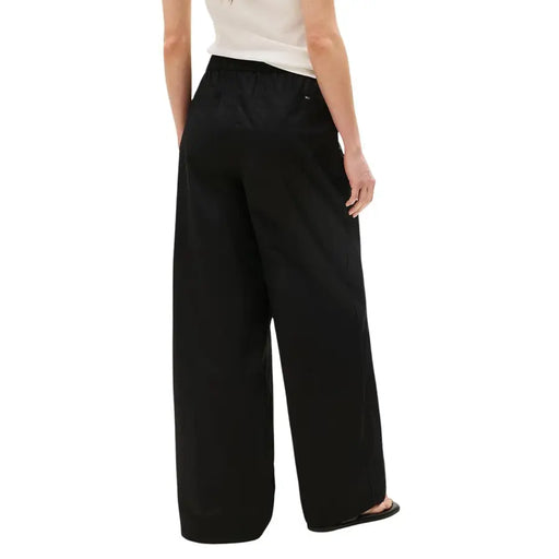 Back side of tommy hilfiger women black organic cotton wide-leg trousers with elastic waistband and subtle logo