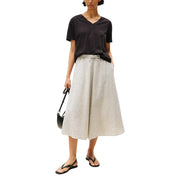 A black and white striped wide-leg skirt with a drawstring waist paired with a tommy hilfiger women black organic cotton v neck t shirt
