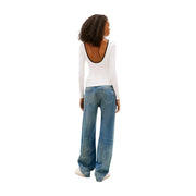Back view of tommy hilfiger women white long sleeve organic cotton t-shirt with black trim paired with blue jeans