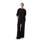 Black cotton Tommy Hilfiger women wide leg sweatpants paired with a black hooded sweatshirt with a small white logo