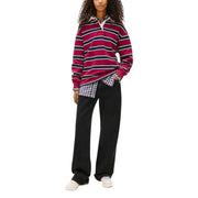 A maroon and navy blue striped long-sleeved polo shirt with a white collar paired with Tommy Hilfiger women’s black organic cotton jeans