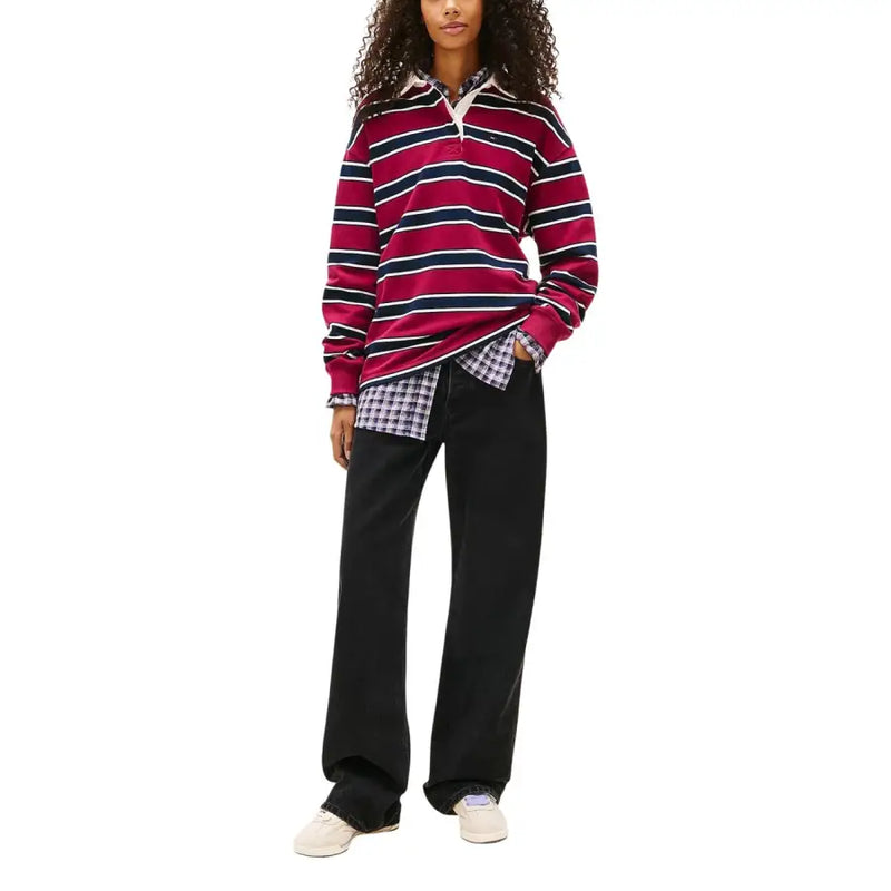 A maroon and navy blue striped long-sleeved polo shirt with a white collar paired with Tommy Hilfiger women’s black organic cotton jeans