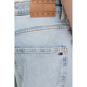 Back side of tommy hilfiger women’s light blue ripped jeans in light-wash denim with tan leather label and flag logo