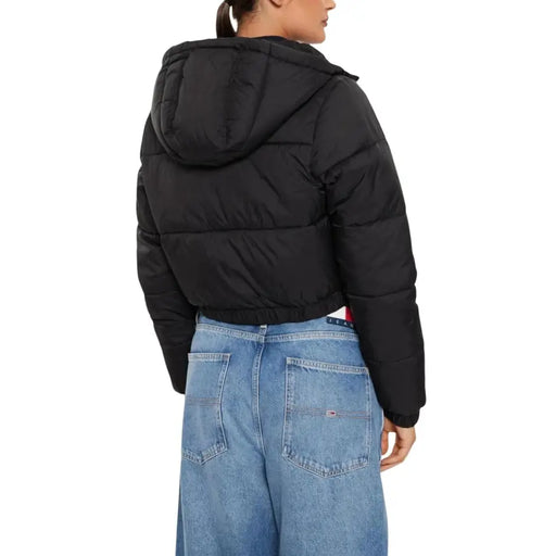 Black hooded puffer jacket with turtleneck paired with light-wash wide-leg jeans
